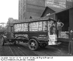 This photo, taken around 1920 in downtown Seattle, shows a Schwabacher Brothers delivery truck with a load of Carnation evaporated milk. The firm was based on Occidental Avenue, with a warehouse and dock at the waterfront. Copyright 2002, Museum of History & Industry. All Rights Reserved.